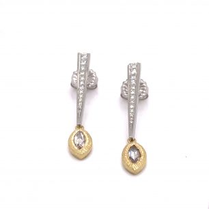 White gold drop earrings with a diamond wrapped in a yellow gold bezel in a marquise shape. The object is set on white background.