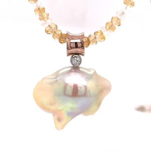 Necklace pendant is made of rose gold and comes with a chain made of beads. The object is set on white background.